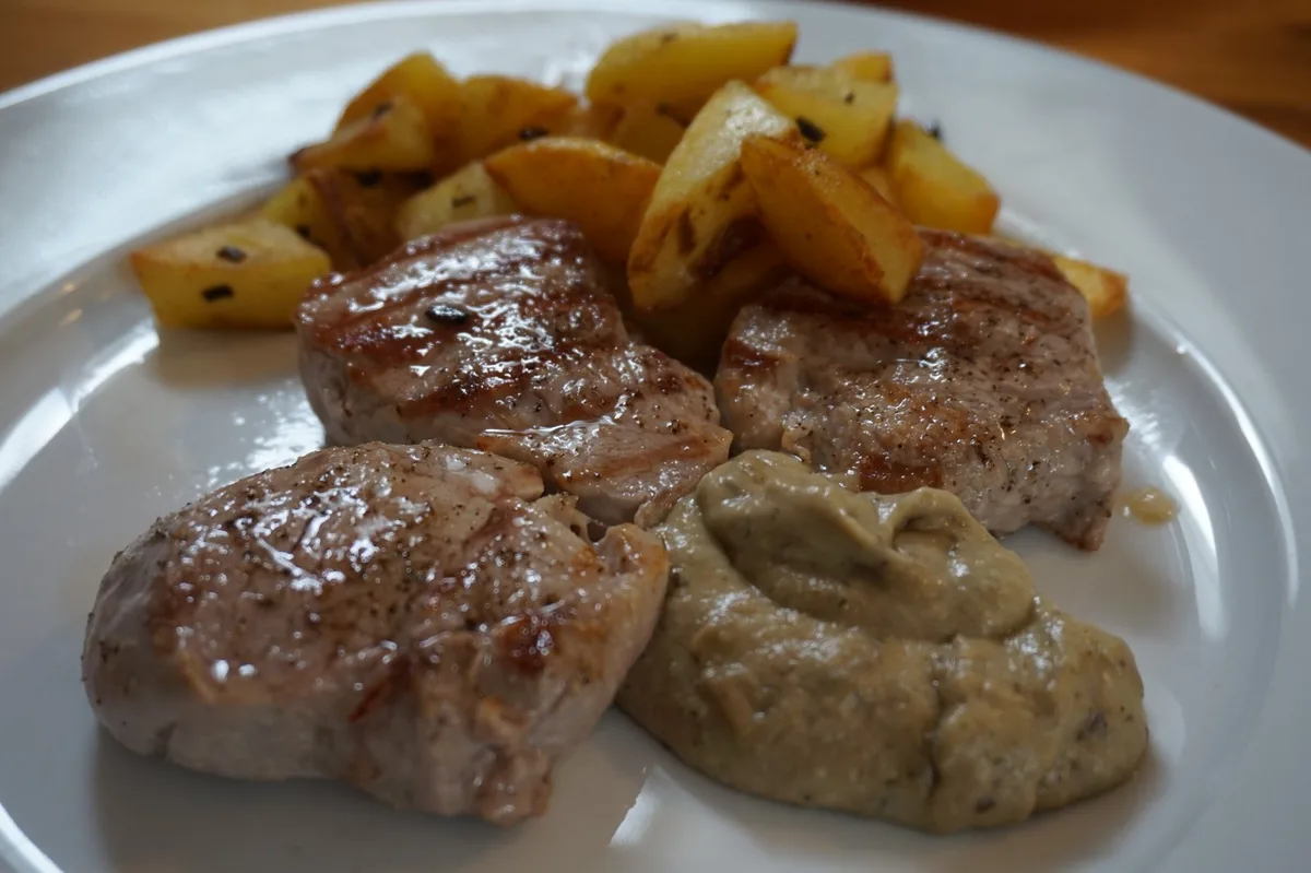 Schweinefilets mit gebratenen Kartoffelwürfeln und Auberginencreme.