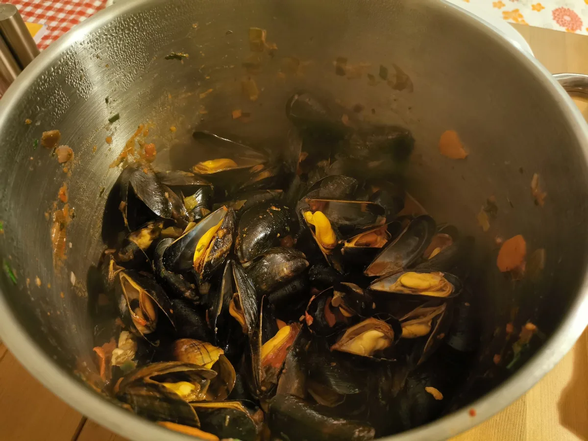 Muscheln werden im Topf mit den restlichen Zutaten vermischt.