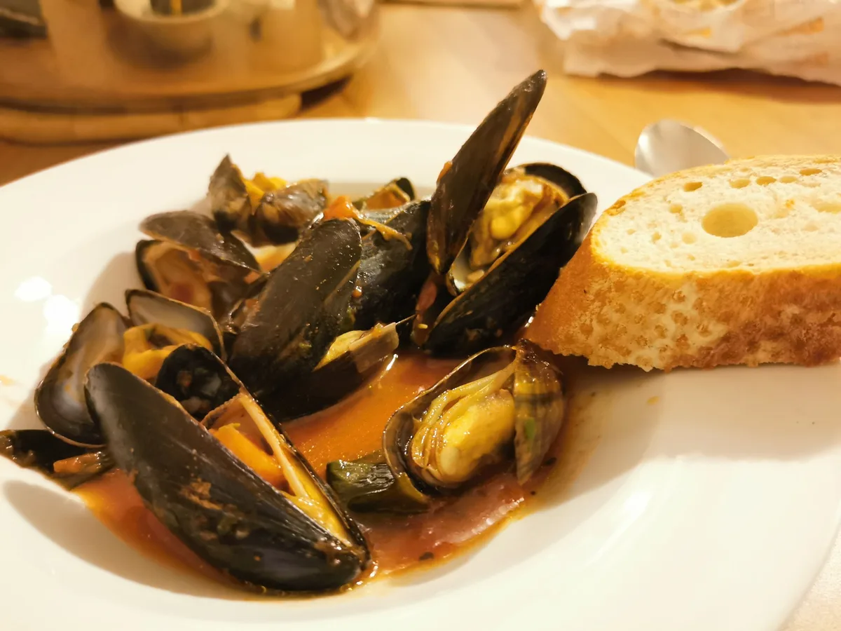 Voilà — Miesmuscheln mit Tomatensud und Weißbrot.